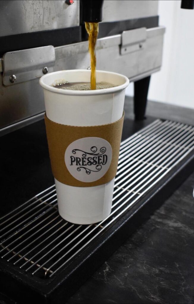 Fresh coffee pouring into a Pressed cup